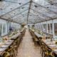 Clear Tent Rental With Bistro Lighting, Wooden Strata Flooring, Farm Tables & X Back Chairs