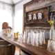 Rustic wedding ideas - Rustic Whiskey Barrel bar rental for wedding, Pilsner Glasses & Barnwood Decor Wall With Bar Sign